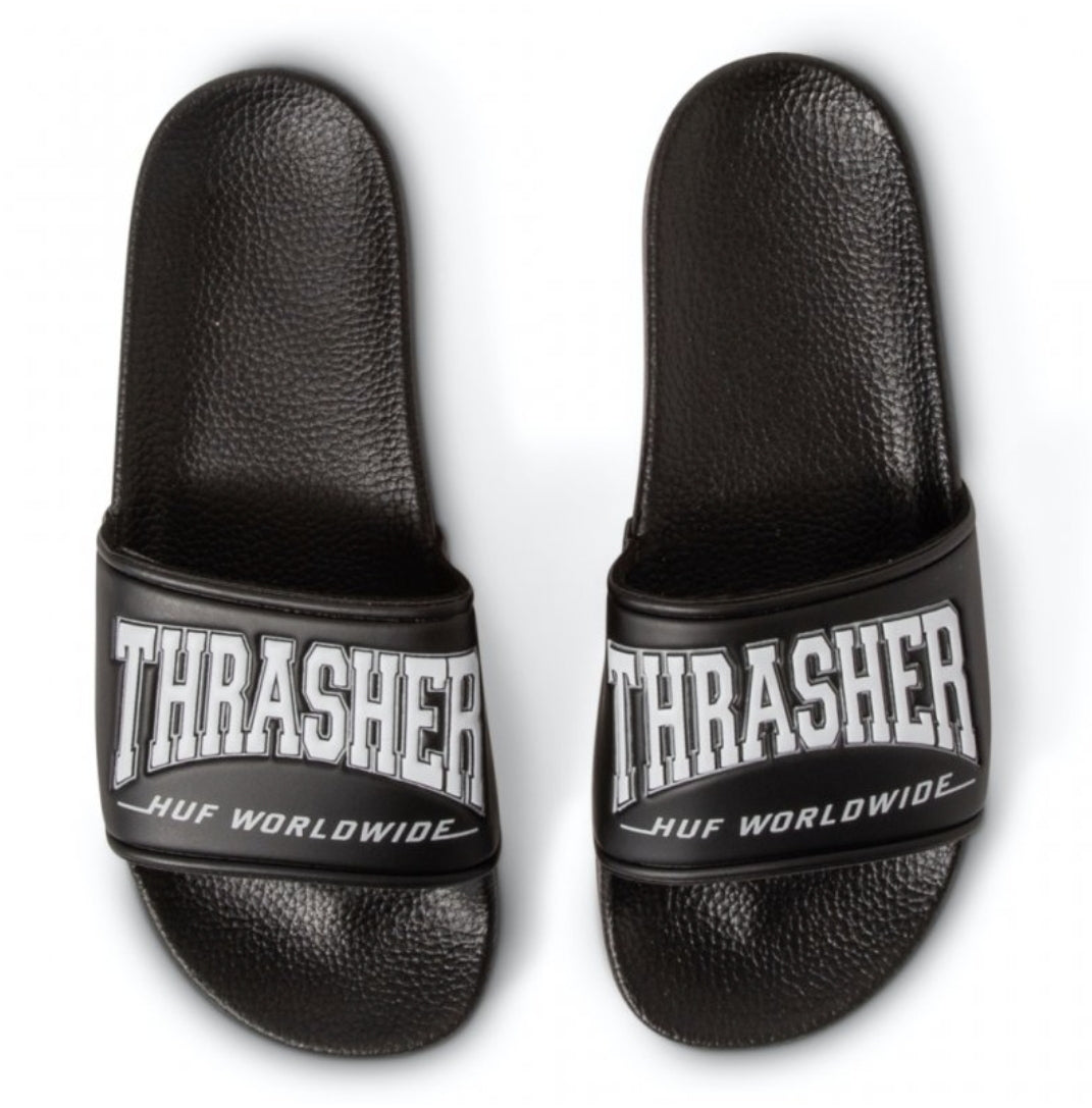 Schwarze HUF x Thrasher Badelatschen mit weißem Thrasher-Logo auf dem Riemen, von oben fotografiert